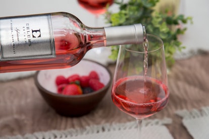 A bottle of Ehlers Estate rosé is being poured into a glass. 