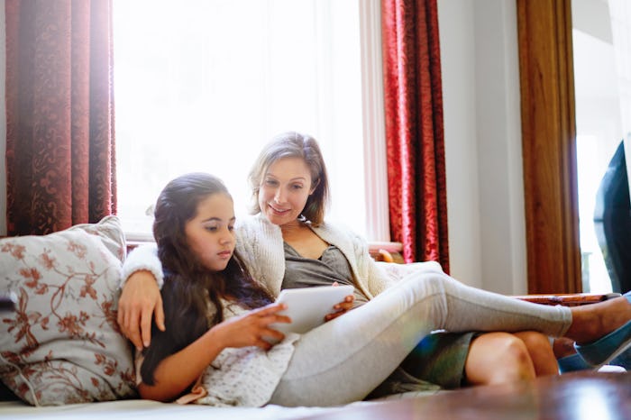 A mother sits with her tween on the couch