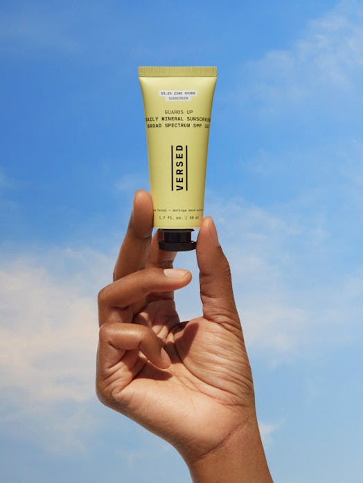 Hand holding up Versed's new Guards Up Daily Mineral Sunscreen.