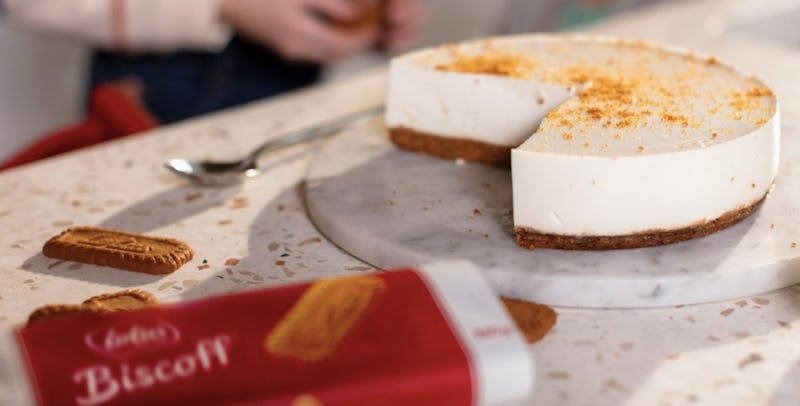 An opened package of biscoff next to a biscoff cake on a cutting board