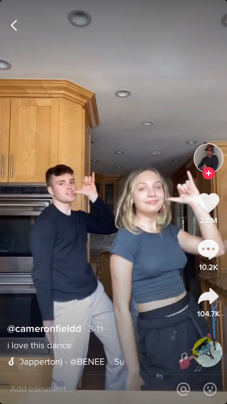 A happy couple dance together in their kitchen. 