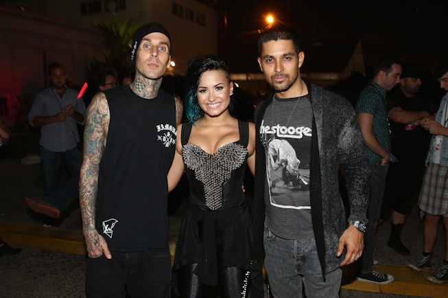 Musician Travis Barker, recording artist Demi Lovato and actor Wilmer Valderrama pose backstage duri...