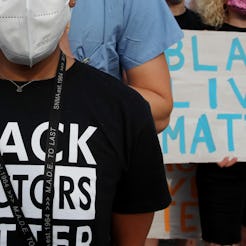 A woman wears a shirt reading "Black doctors matter" at a protest. Talking About Racism Must Be A Pa...