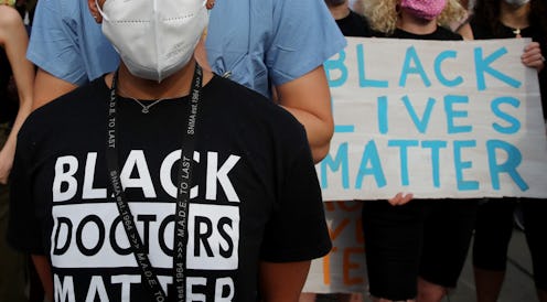 A woman wears a shirt reading "Black doctors matter" at a protest. Talking About Racism Must Be A Pa...