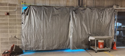 At the Dane County Jail in Madison, Wisconsin, a robot that emits ultraviolet light is behind a tarp...