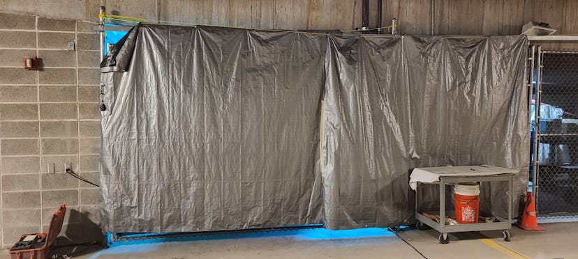 At the Dane County Jail in Madison, Wisconsin, a robot that emits ultraviolet light is behind a tarp...