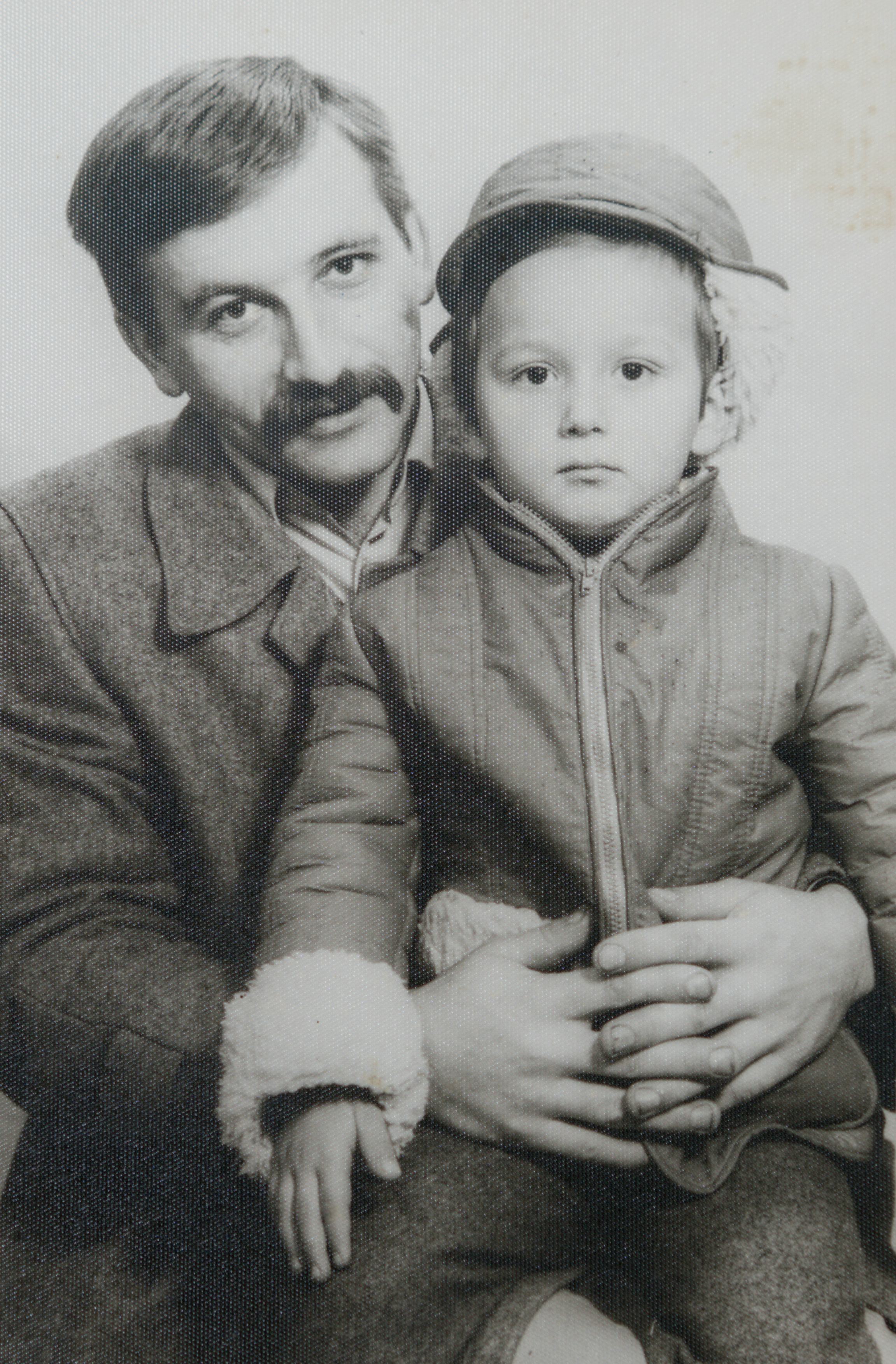 An old black and white photo of a dad holding his child in his lap