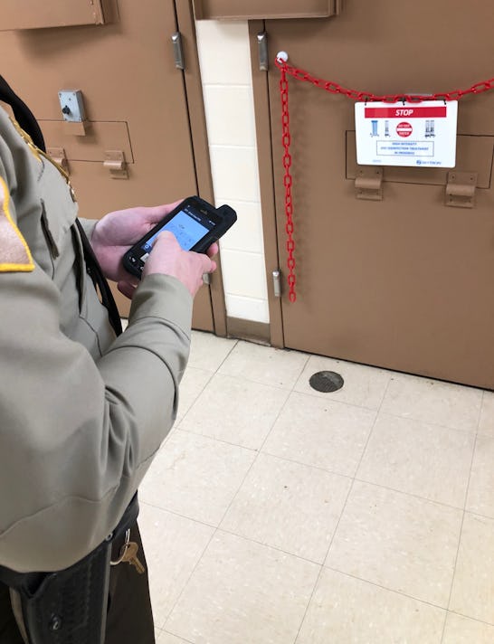 An officer at the Jefferson County Jail in Madison, Indiana, uses a handheld device to operate a mac...
