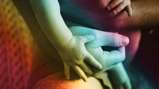 A non-bio parent holding their child; a close-up of their arms