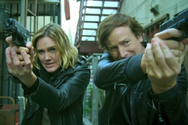 Rob Huebel and Erinn Hayes pointing guns at someone in a scene from Medical Police 