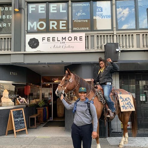 A girl riding a horse while the other one is holding it in front of the Feelmore Adult Gallery in Oa...