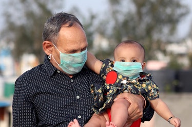 A grandfather and grandson in India wearing masks. 