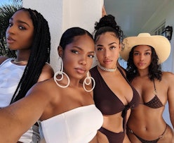 Four black women in bathing suits with sunscreen on