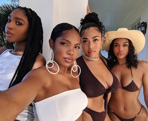Four black women in bathing suits with sunscreen on