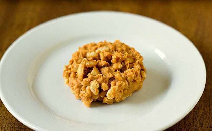 A white plate with a peanut butter cookie atop it.