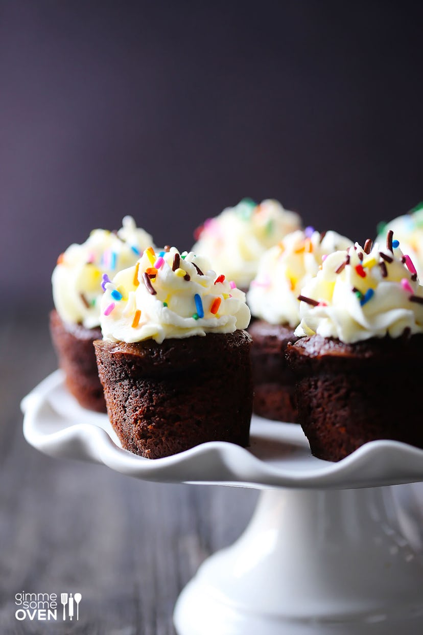 Dense chocolate miniature cakes topped with whipped cream and sprinkles. 