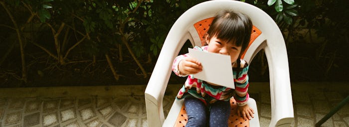 A toddler girl sits on chair