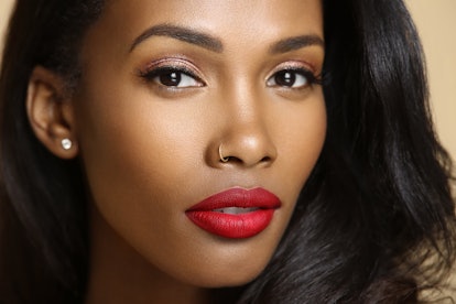 A model with a dark skin tone wears the Lip Bar's Bawse Lady Lipstick