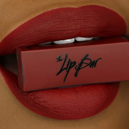 Female lips holding the Lip Bar's Bawse Lady Lipstick shade