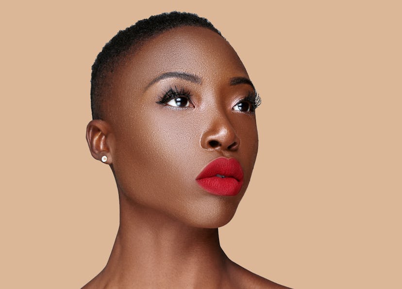 A short-haired model with a darker skin tone wears the Lip Bar's Bawse Lady Lipstick.