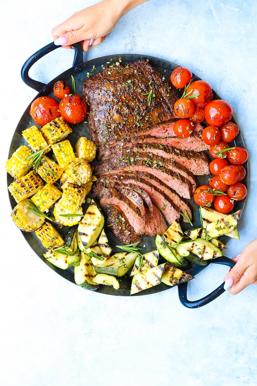 A big plate of grilled sliced flank steak and vegetables. 