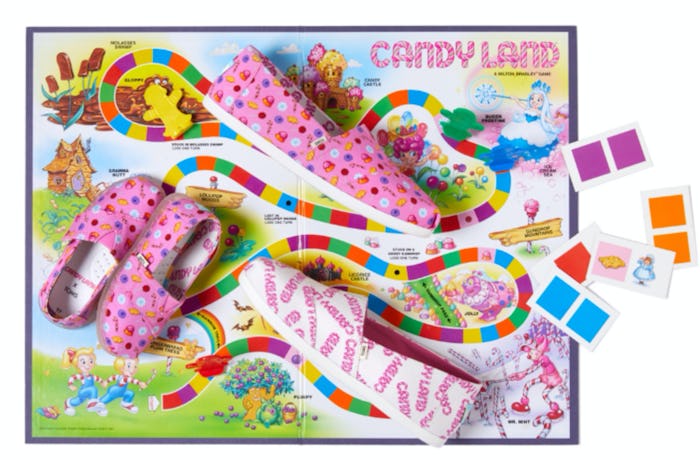 Toms shoes with Candyland prints laying on top of a Candyland board game