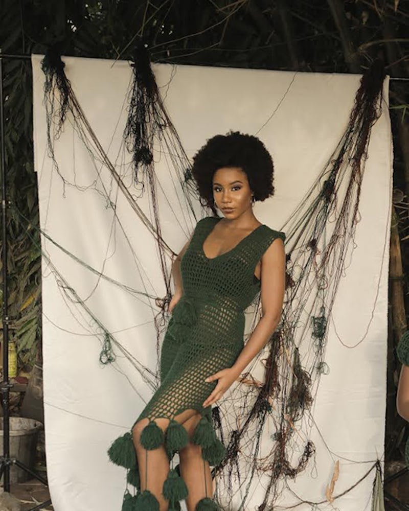 A woman posing in a dark green custom designed crocheted dress