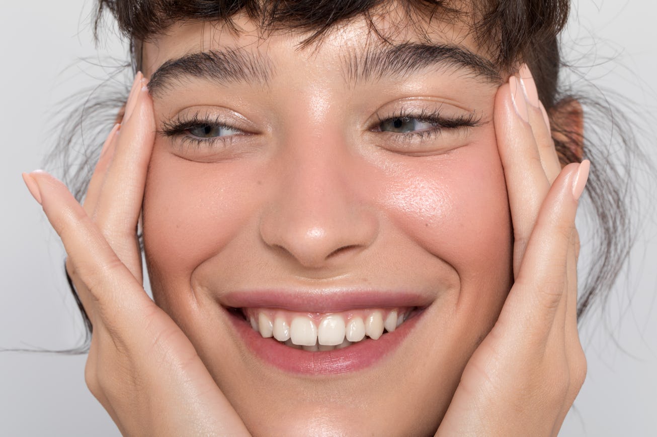 Model holding her face, checking how her new affordable mascara looks