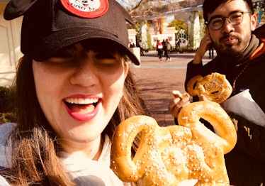 Happy friends hold up their Mickey Mouse pretzels at Disneyland. 