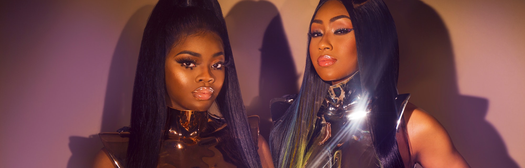 Yung Miami and JT from City Girls, Miami rap duo, posing in a golden armor