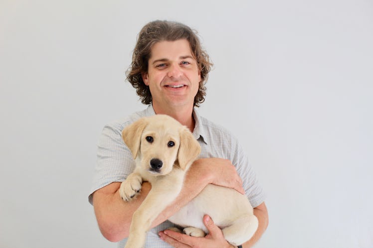 Brian Hare posing while holding a dog