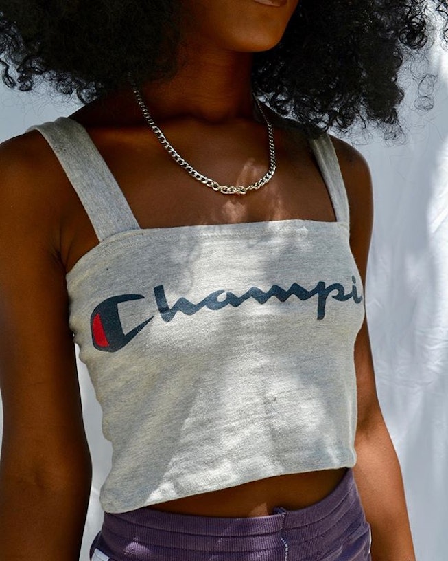 A girl's white top with a Champion logo on it