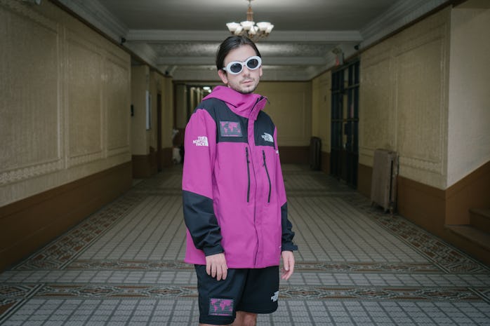 Man standing in lobby wearing jacket.