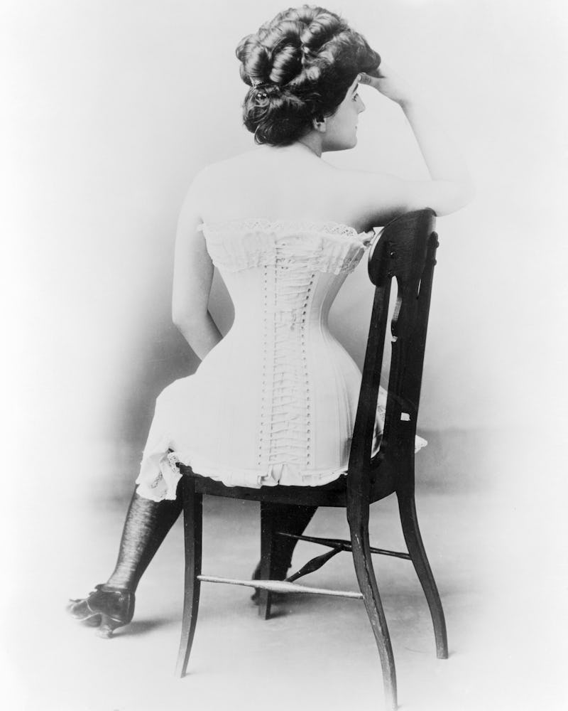 Black and white drawing of a woman sitting in a white corset dress