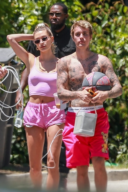 Hailey Bieber wearing pink shorts and a pink tank top.