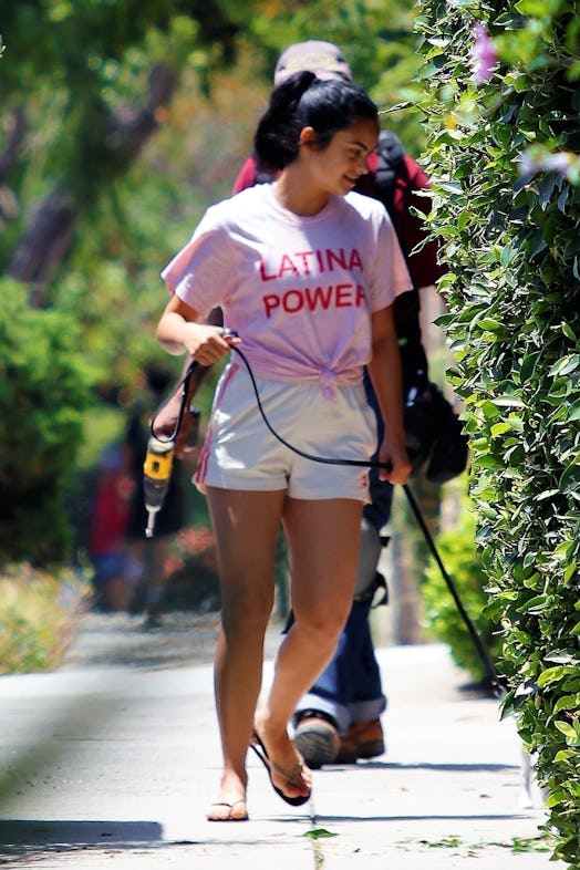 Camila Mendes wearing athletic shorts and a pink T-shirt.