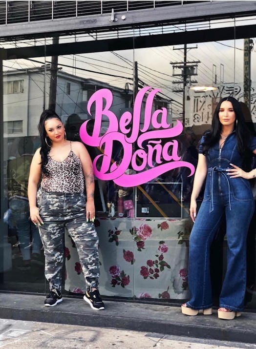 Natalia and Lala posing in front of their clothing line's storefront