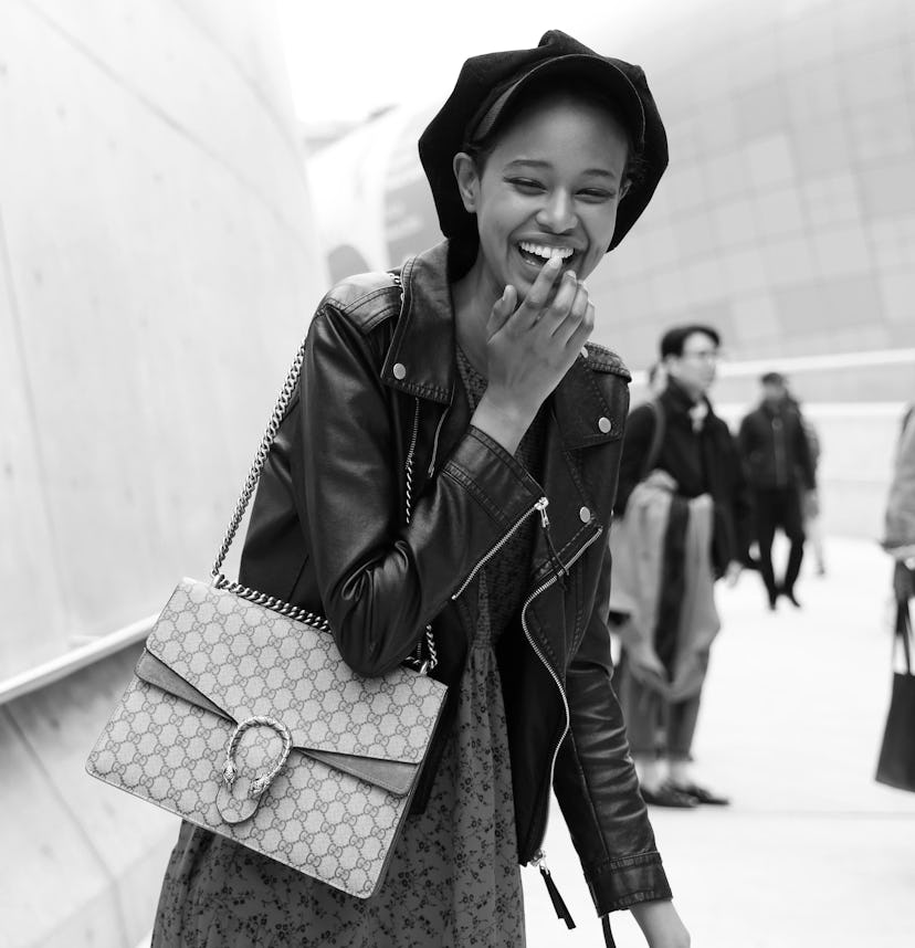 A young lady laughing with a Gucci Dionysus bag on her right shoulder