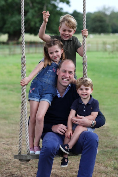 Prince william and royal children sitting on a swing 