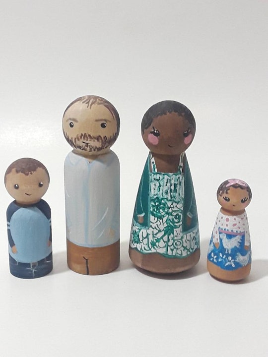 Two peg doll adults and two peg doll children are displayed as a family.