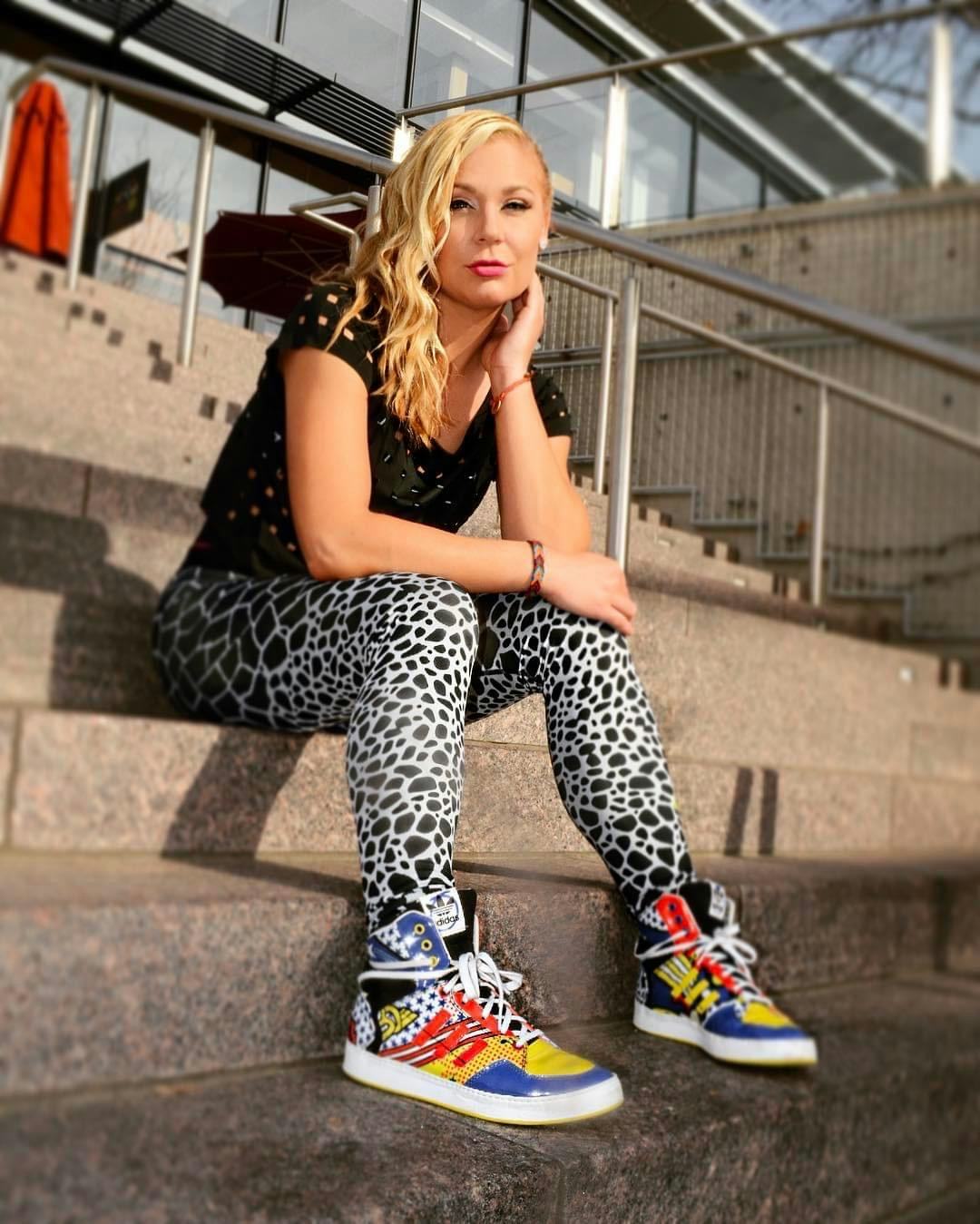 Juli Lawless sitting on the stairs while posing for a photo