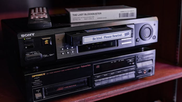 A VCR with a Blockbuster VHS tape in it.