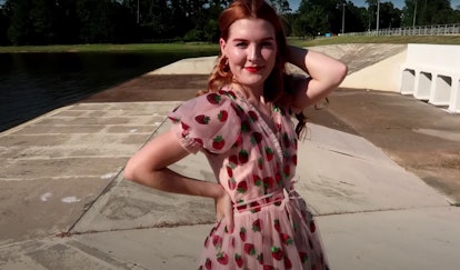 A woman shows off her Strawberry Dress outside. 