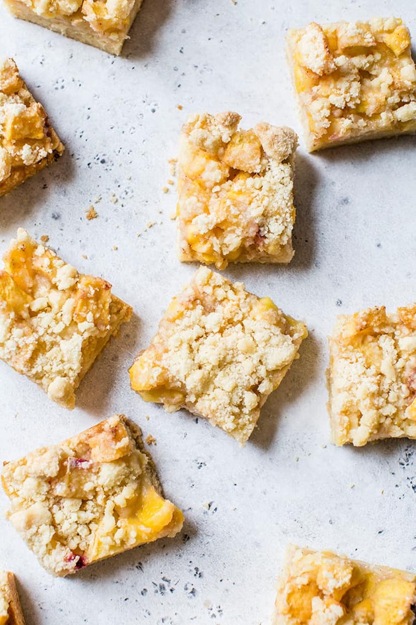 squares of peach bars with crumble on top.