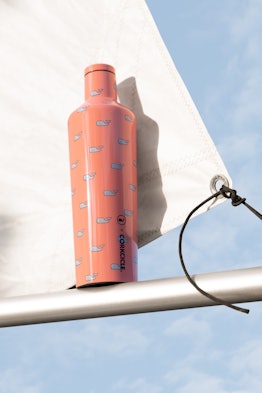 A canteen from the Corkcicle x Vineyard Vines limited edition collection sits next to a boat's sail ...