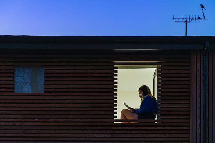 Teenage girl sitting in her window at home.