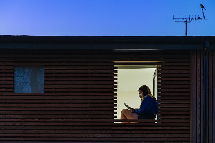 Teenage girl sitting in her window at home. 