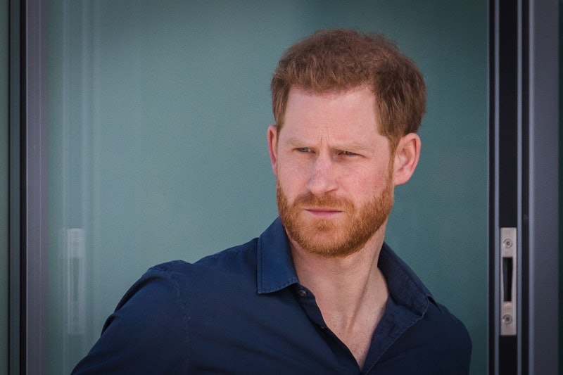Prince Harry looking concerned wearing a blue shirt