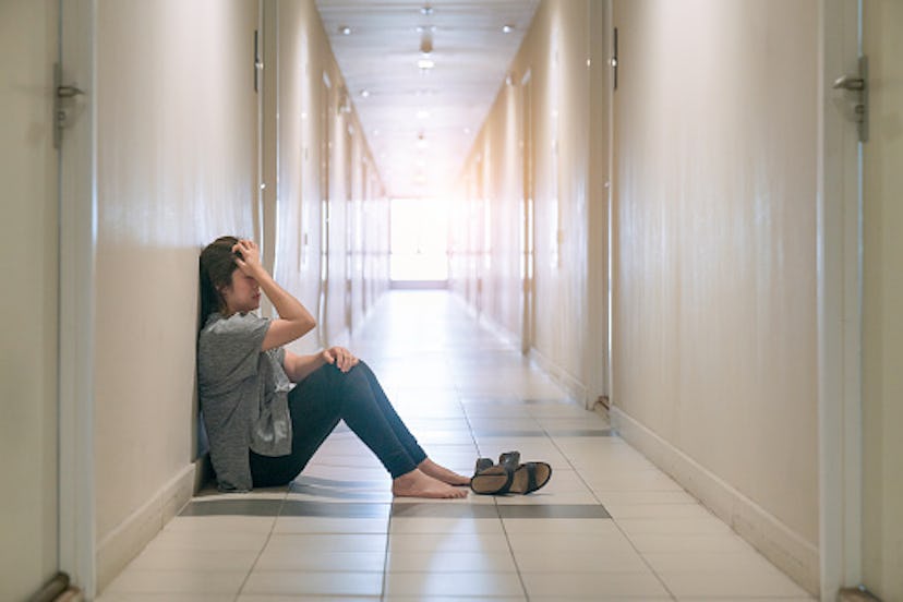 woman feeling sad sitting in hallway