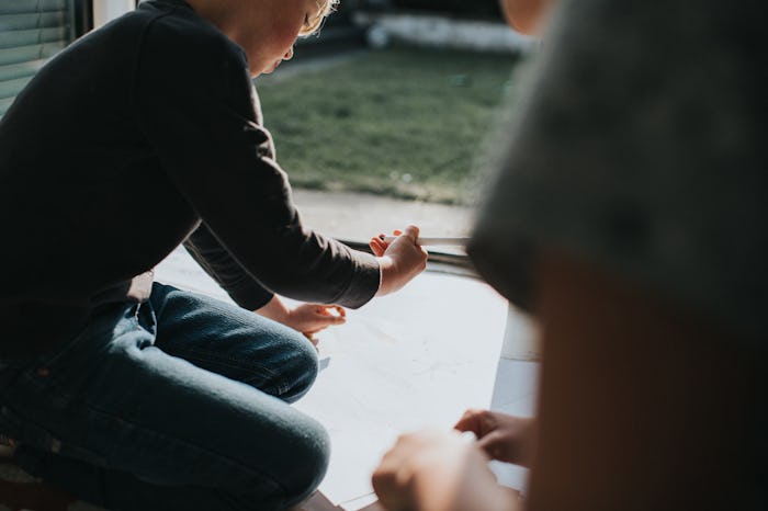 Young boy drawing in a sunny room with felt tip pens.